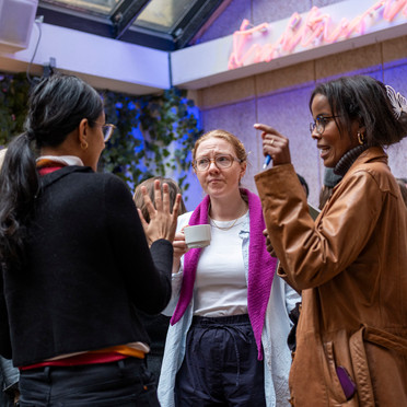 Tre kvinner engasjert i samtale.