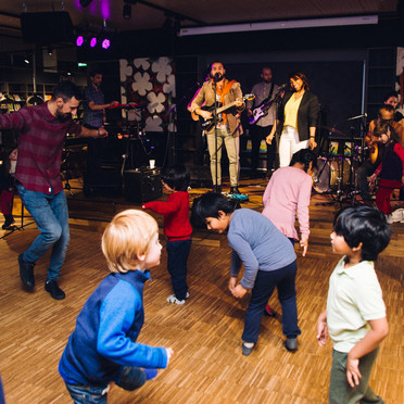 Konsert med dansende barn i forgrunnen.