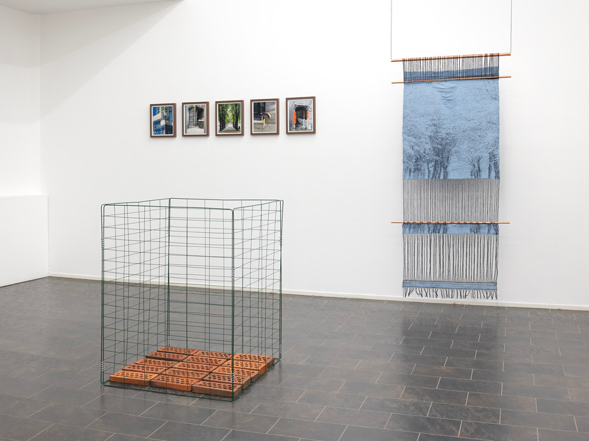 Bildet viser det innerste rommet i RAM galleri. Sentralt i rommet, plassert på gulvet, står en kubeformet kompostbinge. Bunnen av kuben er fylt med kuttede teglsteiner.

På bakveggen, fra venstre, henger fem små fotografier i like rammer, montert i en horisontal rekke. Motivene i fotografiene er tatt i Kvadraturen, området der galleriet ligger, og viser urbane detaljer som midlertidige stillaser, rør og passasjer. Et av fotografiene viser også trær fra Paléalléen nederst i Kvadraturen.

Til høyre på veggen henger et langt, smalt håndvevd tekstil i en isblå fargetone. Tekstilet er festet øverst og på to steder langs lengden med horisontale kobberrør. Nederst avsluttes tekstilet med lange frynser som henger fritt ned mot gulvet. Motivet i det isblå tekstilet bygger på et fotografi fra Paléalléen.