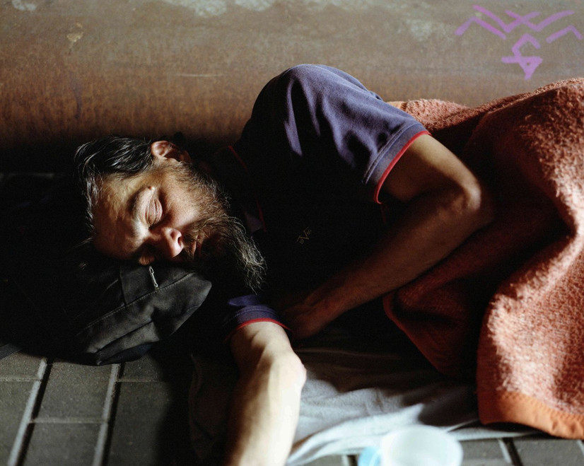 Analogt kopiert fotografi av sovende hjemløs mann, fotografert i Berlin i september 2023.