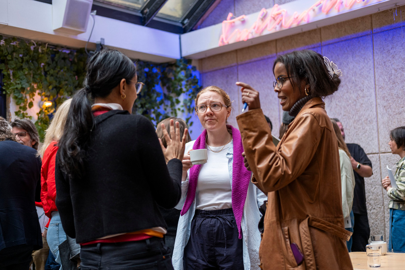 Tre kvinner engasjert i samtale.