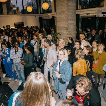 En feststemt folkemengde i et stort lokale.