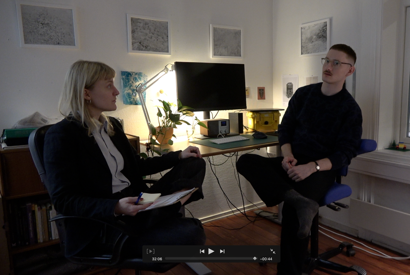 Bildet er et skjermbilde fra en film, som viser to personer i en samtale om kunstpraksis.