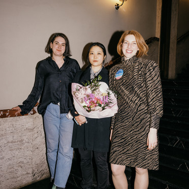 Tre personer står side om side: Jasmina Kemura (kunstfaglig rådgiver i KPA), kunstner Naeun Kang og Frida Rusnak (daglig leder i Oslo Open). Naeun Kang holder en blomsterbukett.
