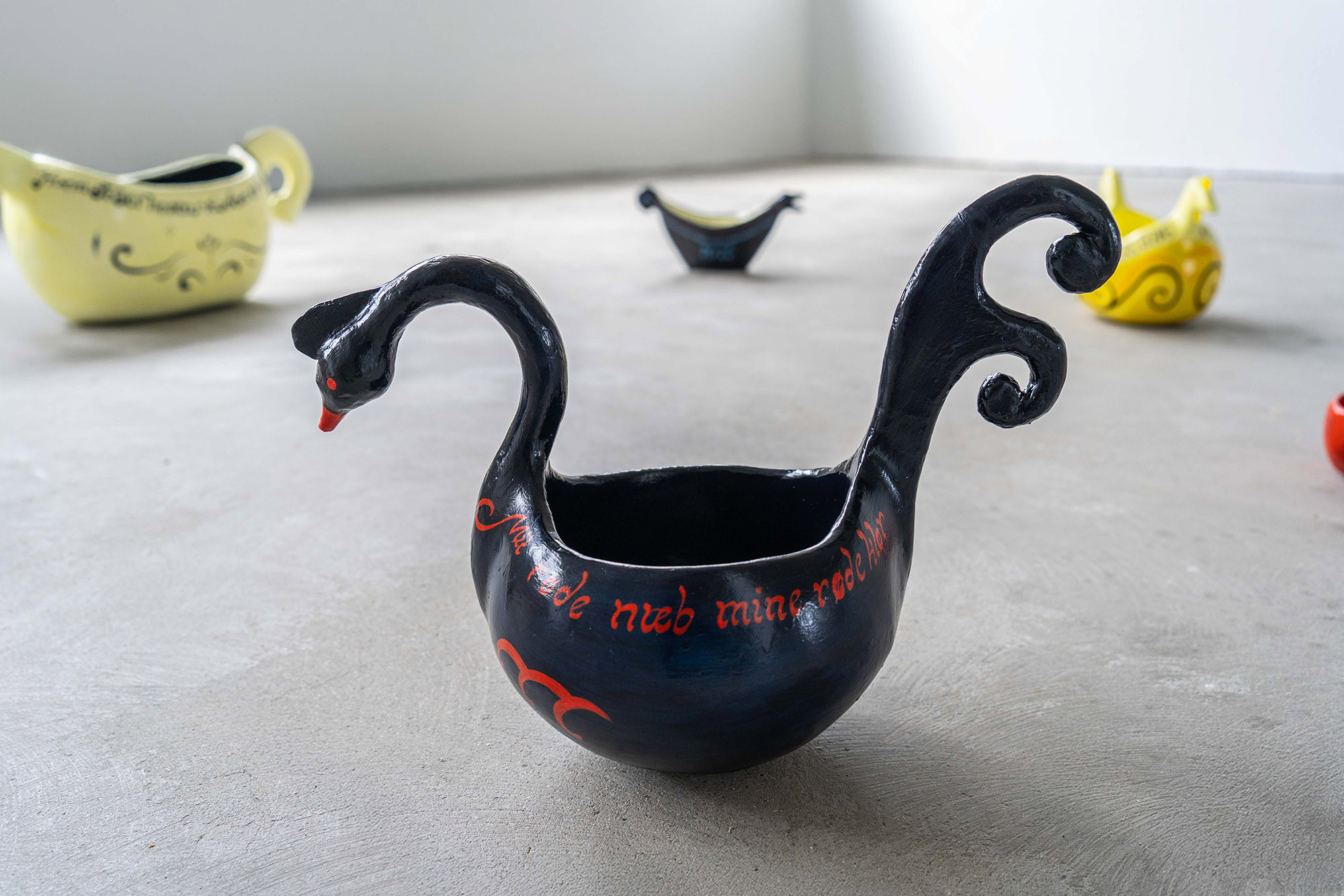 Ølboller med fantasifulle fuglehoder og stjerter står utover gulvet.