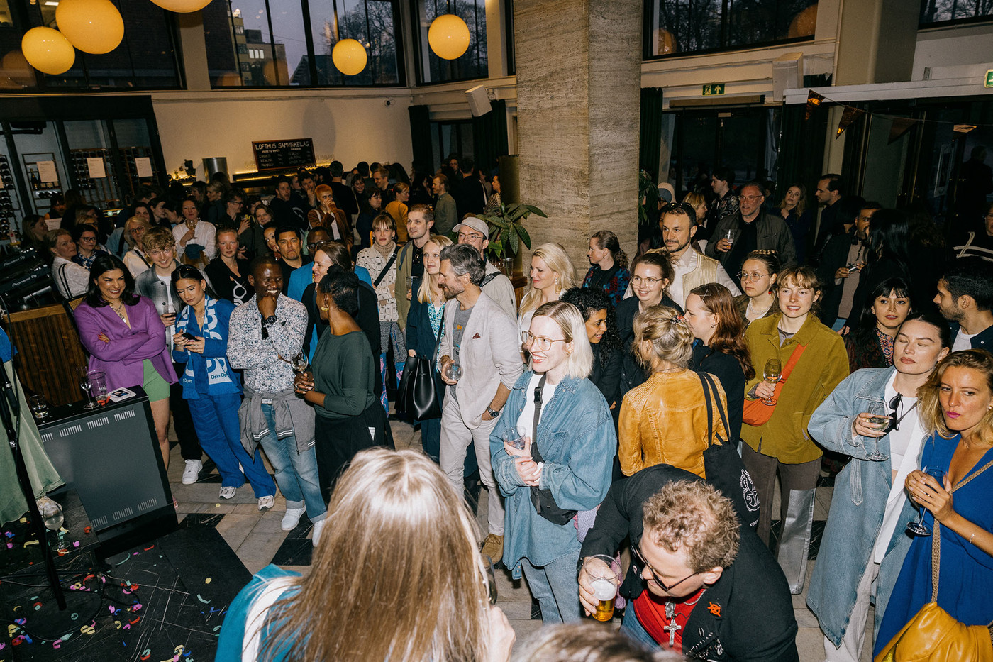 En feststemt folkemengde i et stort lokale.