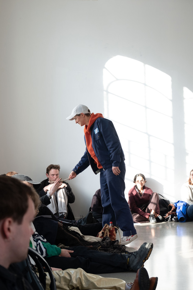 En performer rekker en pinne til en person i publikum. 