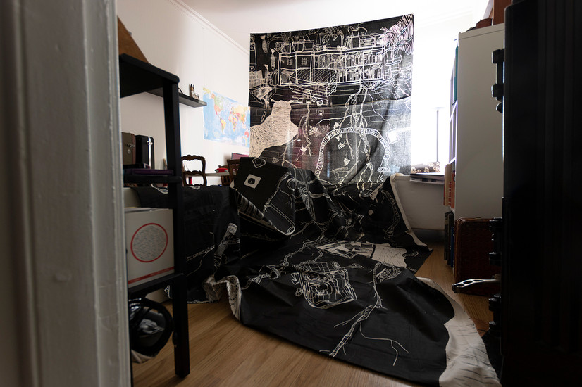 Foto av et tresnitt på 7 meter, tatt inne i en stue full av møbler. Tresnittet er på tekstil og dekker nesten hele rommet og møblene.